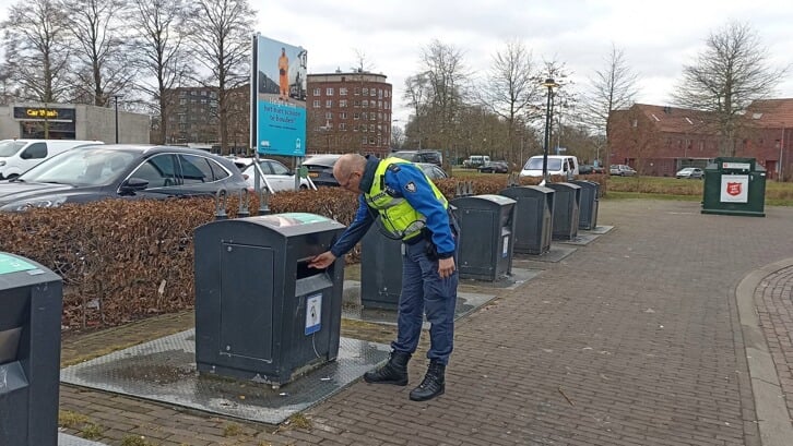 Een handhaver voert een controle uit bij een ondergrondse container. (foto: gemeente Midden-Groningen)