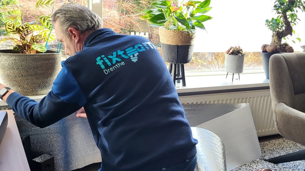 Een van de medewerkers van het Fixteam Drenthe is bezig om radiatorfolie aan te brengen. (foto: gemeente Tynaarlo)