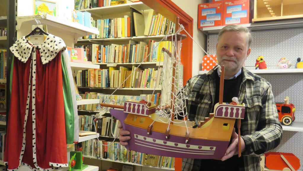 Eigenaar Sikko Geertsema in zijn winkel vol houten speelgoed en boeken.