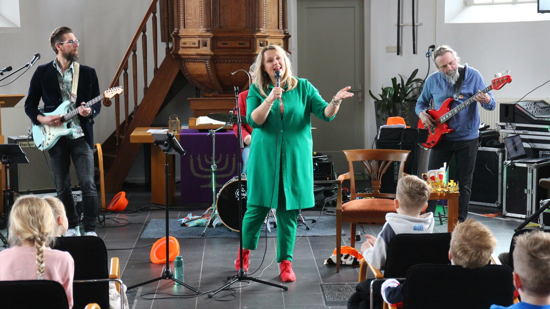 Martijje en haar band laten de kinderen in de Dorpskerk enthousiast  'metzingen'.