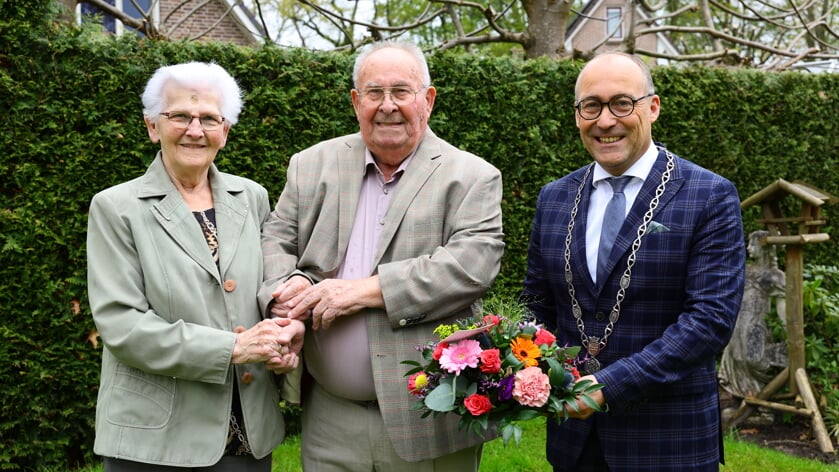 Trientje en Henk Hadderingh uit Gasselte kregen een mooi boekt van burgemeester Anno Wietze Hiemstra. (foto: Week in Week uit)