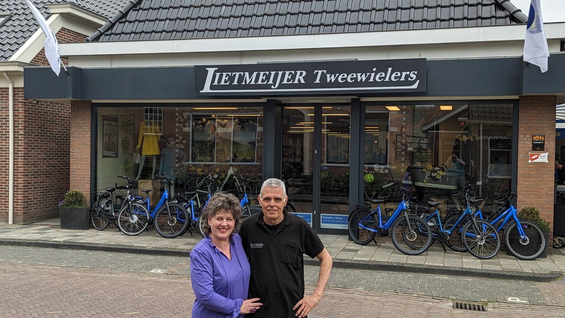  Anky en Jan Lietmeijer voor hun fietsenzaak aan de Schoolstraat in Uithuizen.  