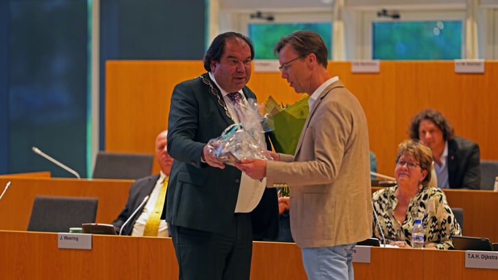 Erik Gerritsen krijgt bloemen en een schaal bij zijn afscheid als raadslid van de gemeente Tynaarlo.