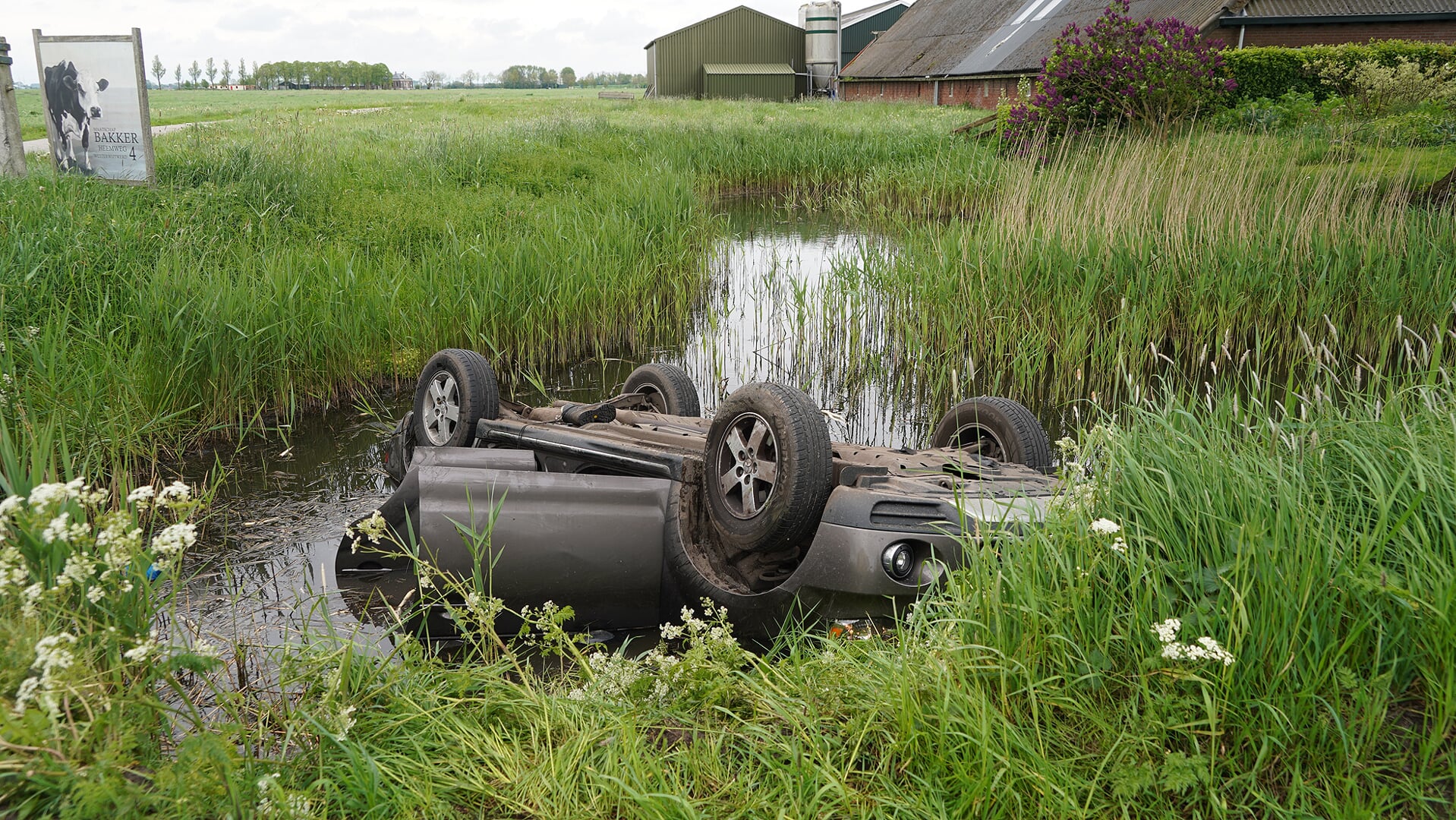 De auto belandde op de kop in de sloot (foto Remco van den Berg).