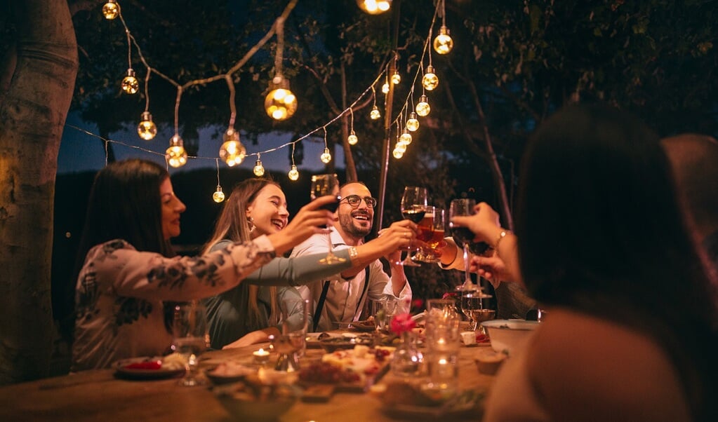 Happy young friends having fun and toasting around mediterranean dinner party table in Italian countryside|