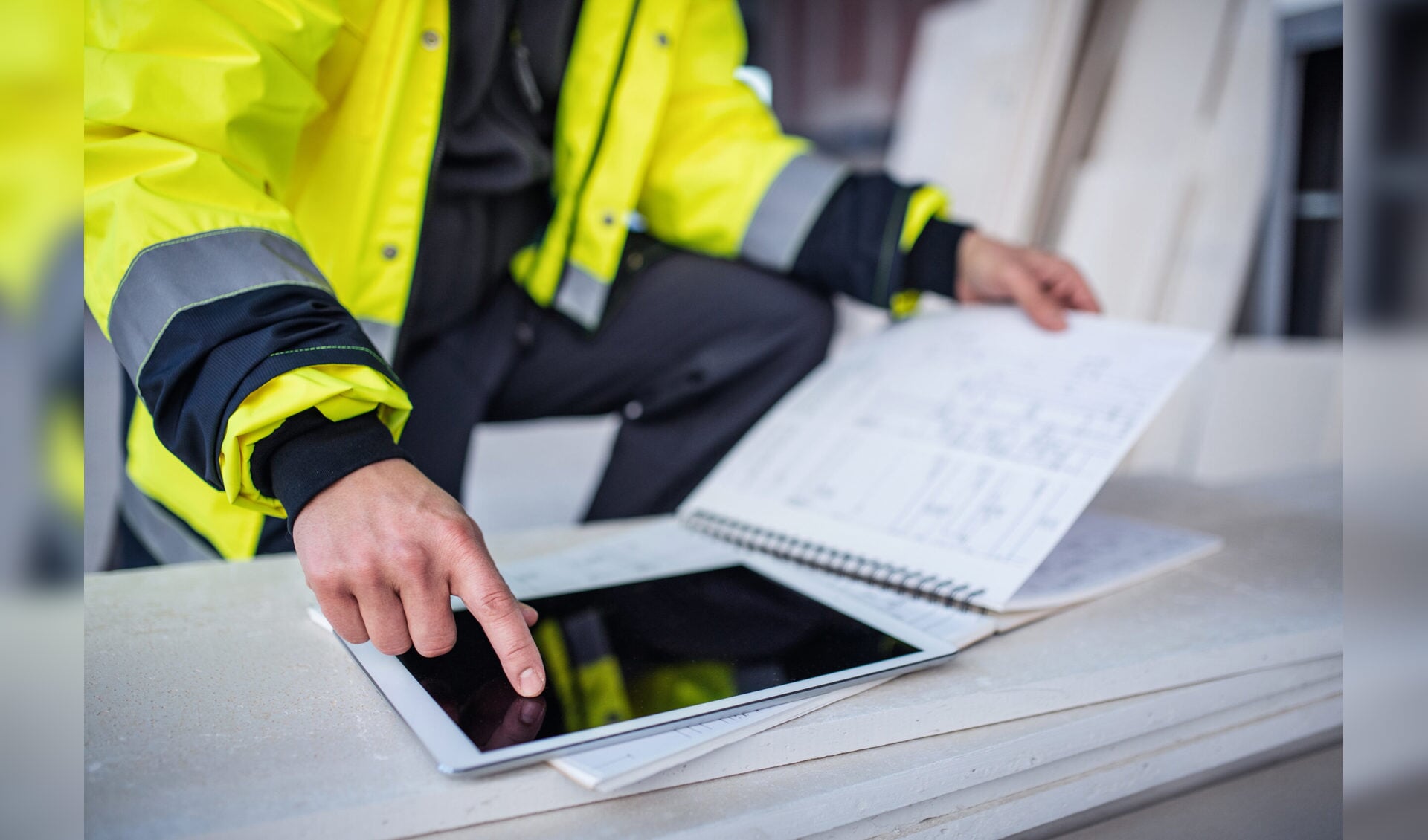 Unrecognizable man engineer standing on construction site, holding tablet with blueprints.|Front view of men engineers standing outdoors on construction site, using tablet. Copy space.