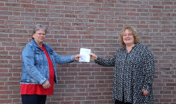 Dinie overhandigt Rosemarie de 1e gedichtenbundel