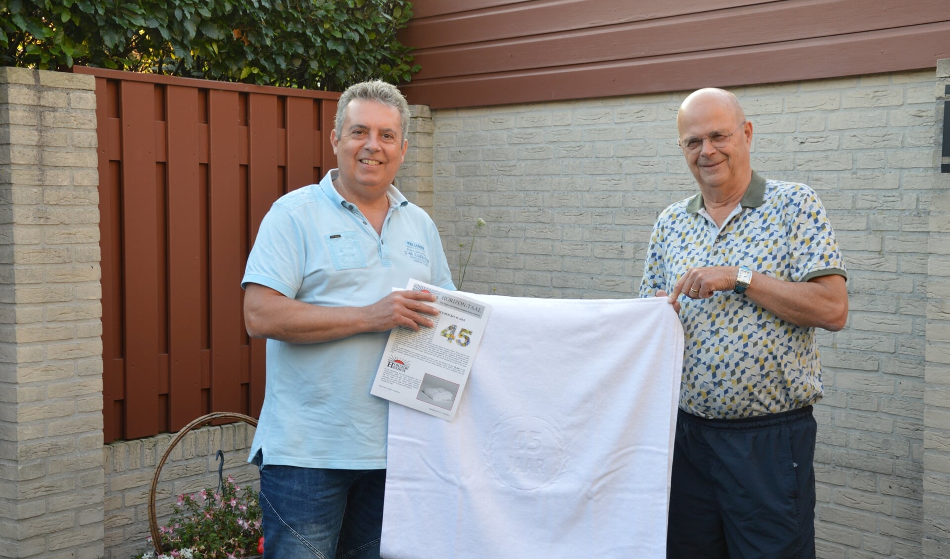 Voorzitter Gerrit-Jan Leeijen overhandigt het eerste exemplaar aan oudvoorzitter en erelid Jan van der Leest  