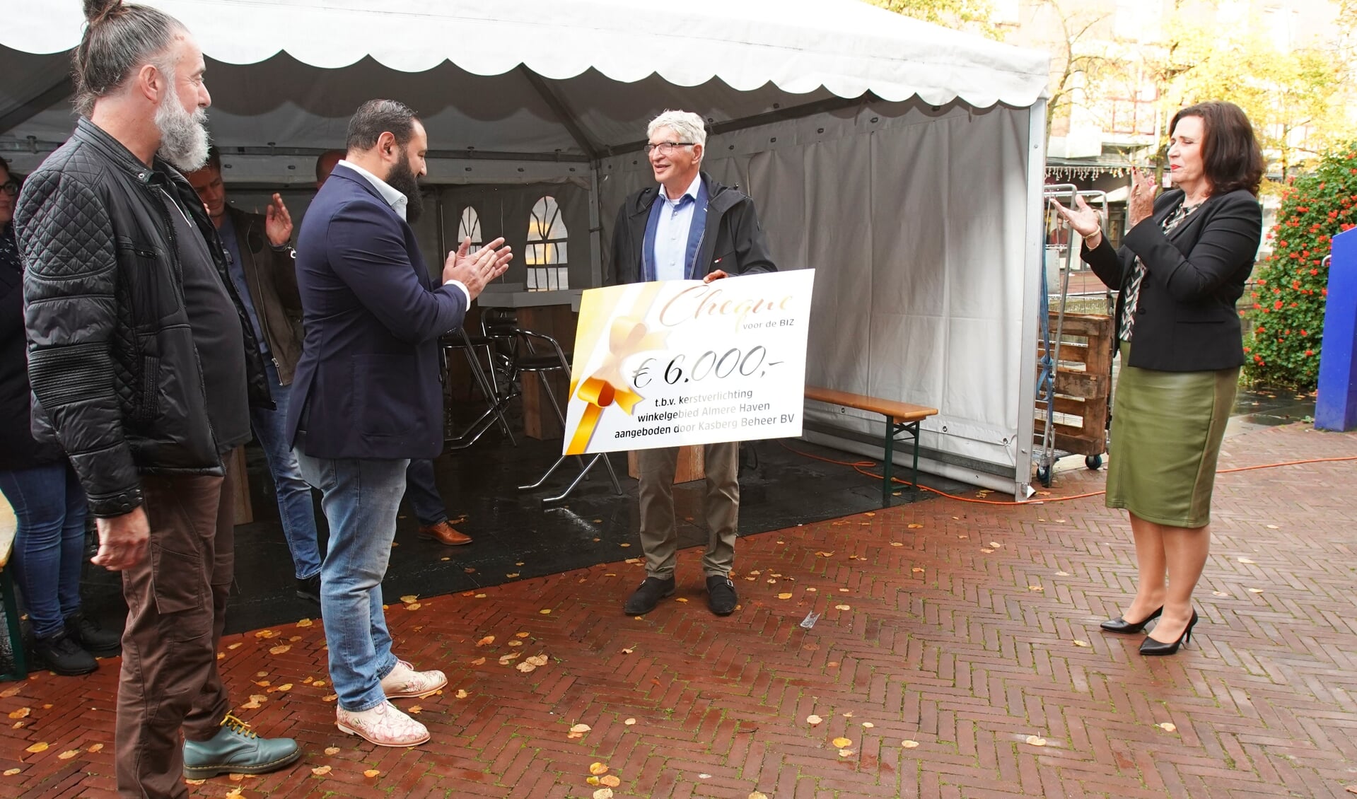 Vastgoedeigenaar Gert van de Glind gaf bij de opening van de nieuwe Roef een cheque aan de BIZ Almere Haven ten behoeve van kerstverlichting in het centrum. (Foto: Fred Rotgans)
