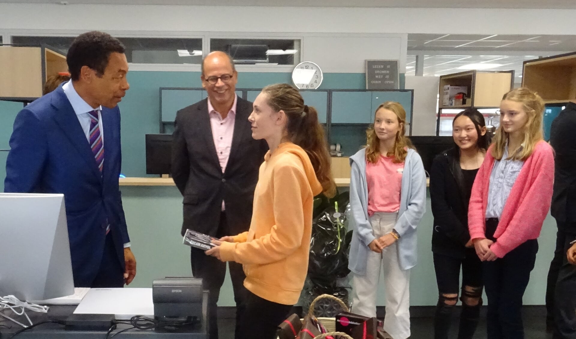 Franc Weerwind leent het eerste boek uit aan een OVC-leerling (Foto: aangeleverd)