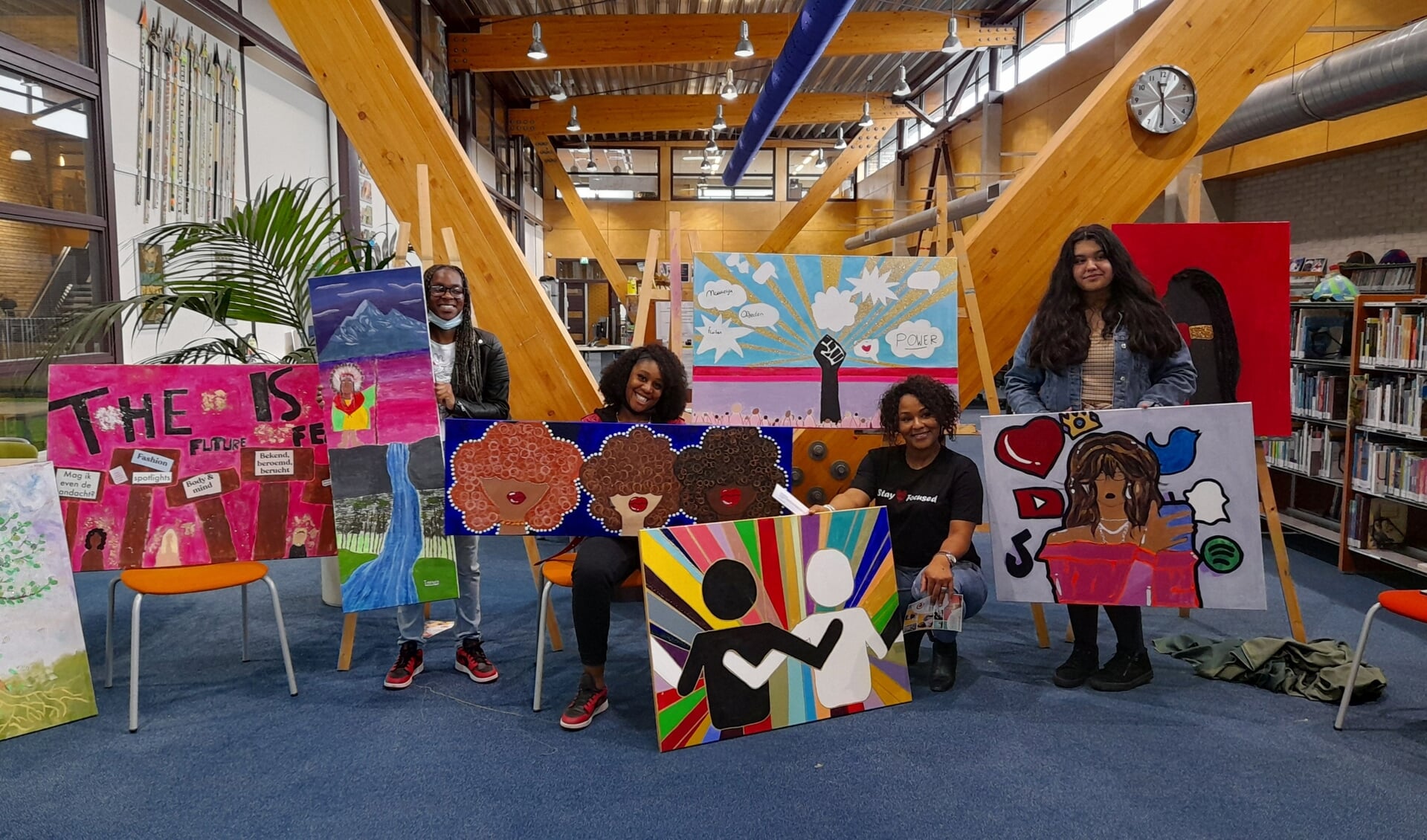 Kunstenares Ailyne Stein (tweede van rechts) en een aantal leerlingen tonen trots de gemaakte kunstwerken. (Foto: Almere DEZE WEEK)