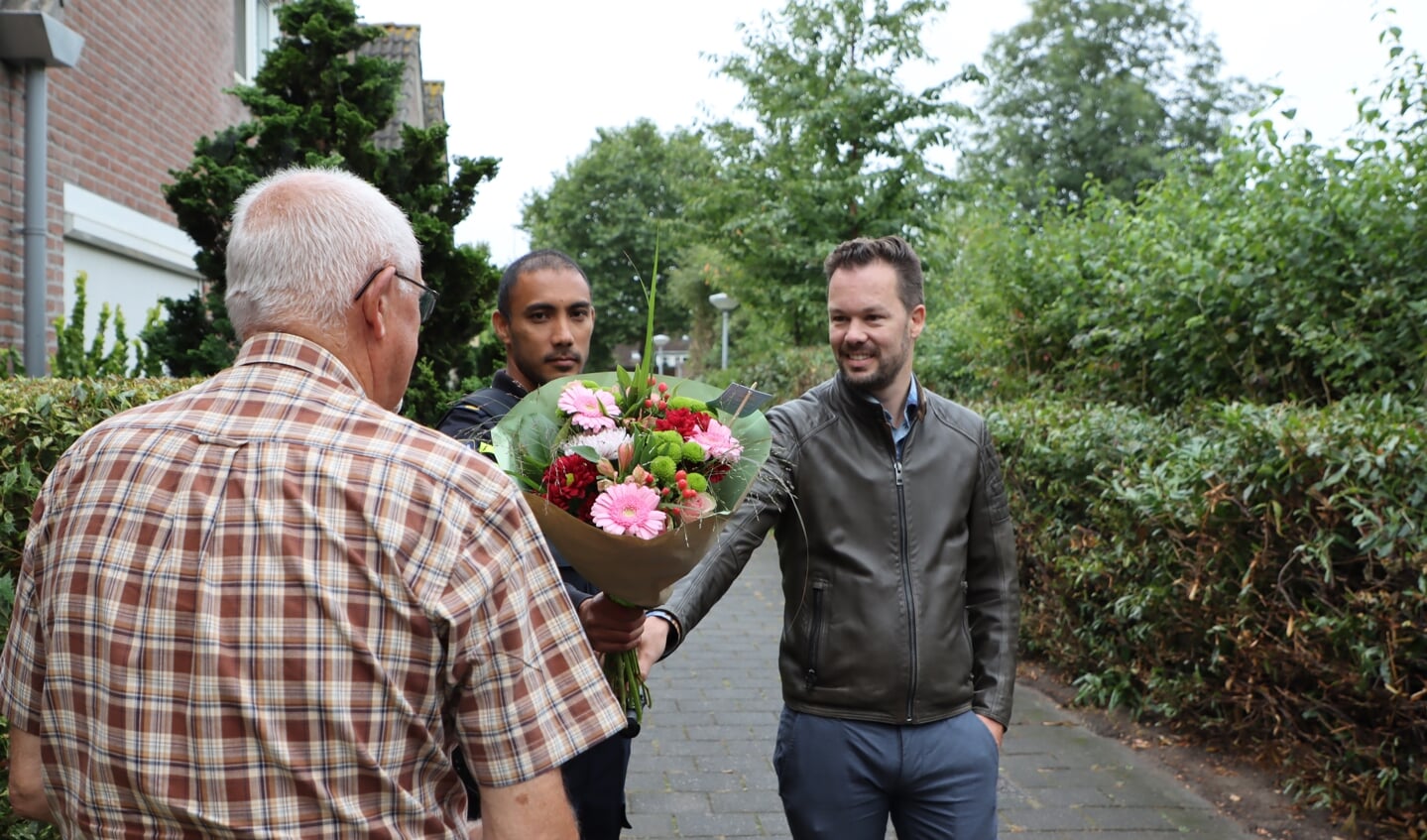 De bewoners, die niet herkenbaar op de foto wil, kreeg een bloemetje als dank. (Foto: Studio Rotgans/RInus Lettinck)