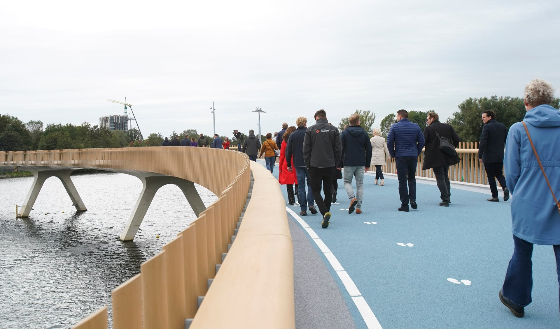 De eerste mensen lopen over de Weerwaterbrug. Op de achtergrond het Floriadeterrein. (Foto: Fred Rotgans)