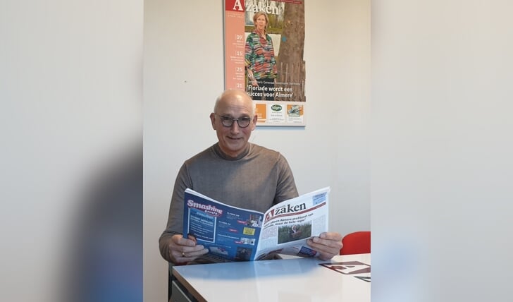 Ben Scholten bladert door de eerste uitgave van Almere Zaken, met daarin zijn eerste column. (Foto: Almere Zaken)