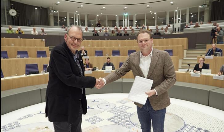 Bewoner Fred van Brussel (links) overhandigt de petitie aan voorzitter Koen Bokhorst. (Foto: aangeleverd)