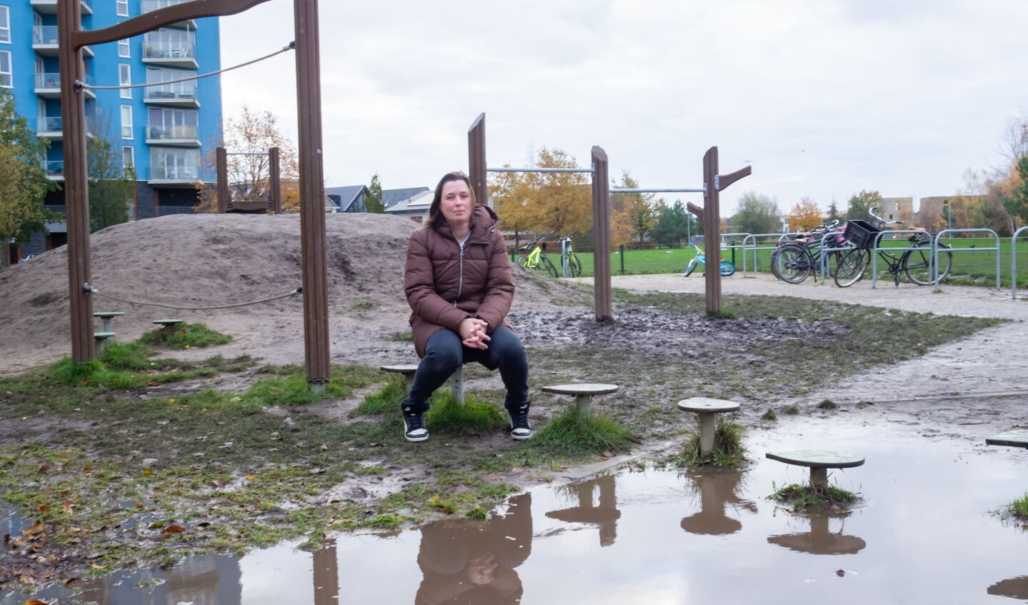 Moeder Hannah Meijer in het modderige speeltuintje bij basisschool de Odyssee in Poort. (Foto: Almere DEZE WEEK)