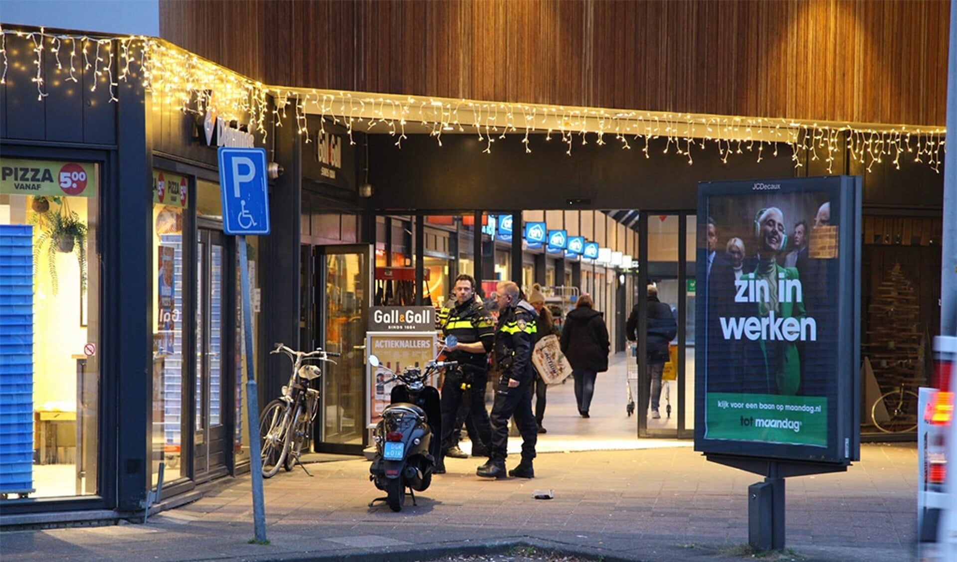 Agenten staan bij de pizzeria, verderop is de AH te zien. (Foto: HV Almere)