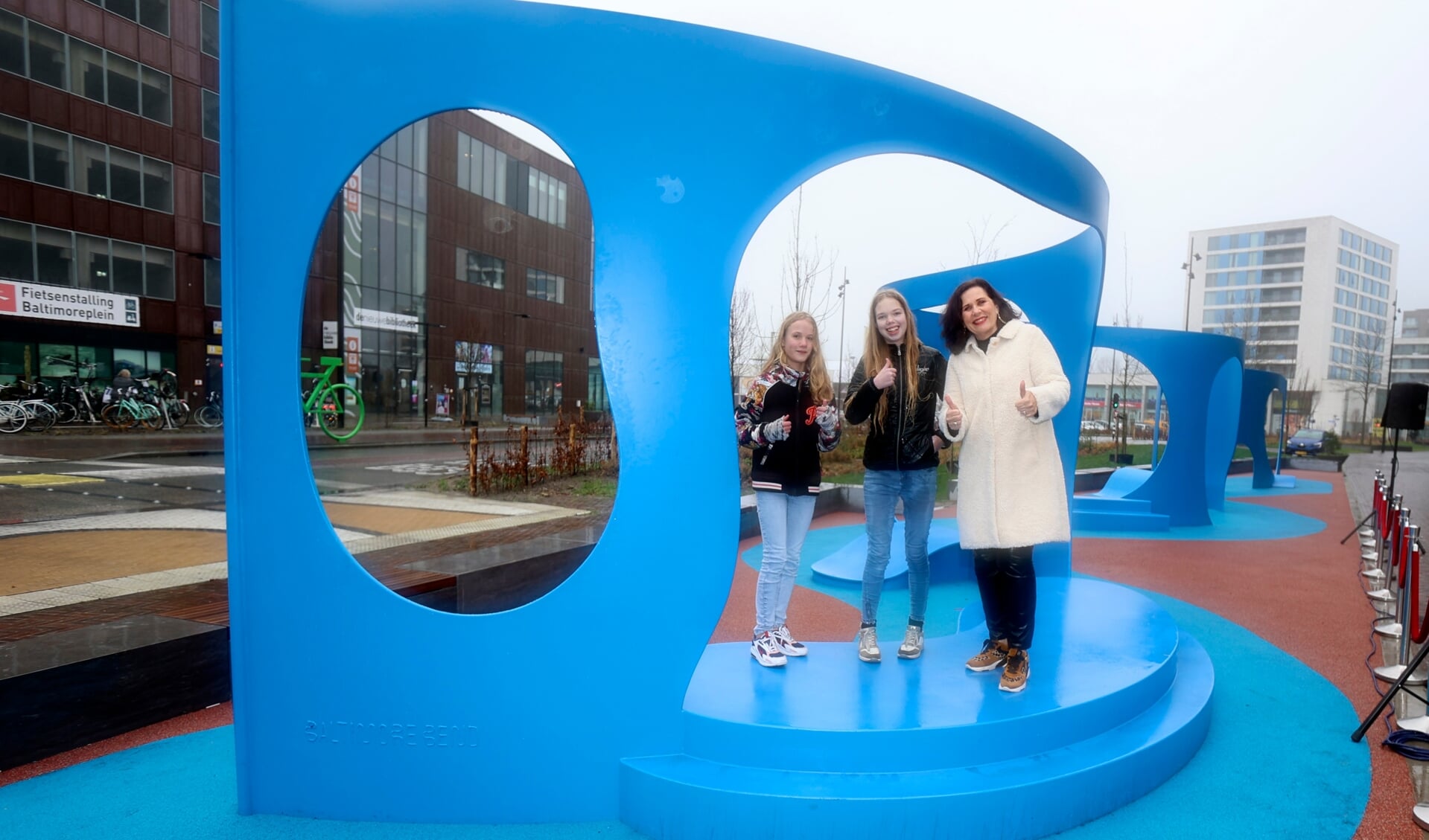 Marlie en Eline hebben samen met wethouder Hilde van Garderen het nieuwe speelkunstwerk geopend op het Baltimoreplein. (Foto: Fred Rotgans