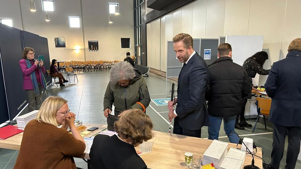 Hugo de Jonge helpt slechtziende vrouw in stembureau (Foto: Almere DEZE WEEK)