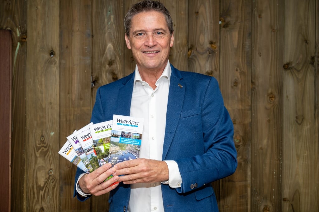 Ronald Schut, bedenker en uitgever, met de vijf verschillende edities Wegwijzer Almere 2021-2022. (Foto: Erik Daams in-gooi.nl)