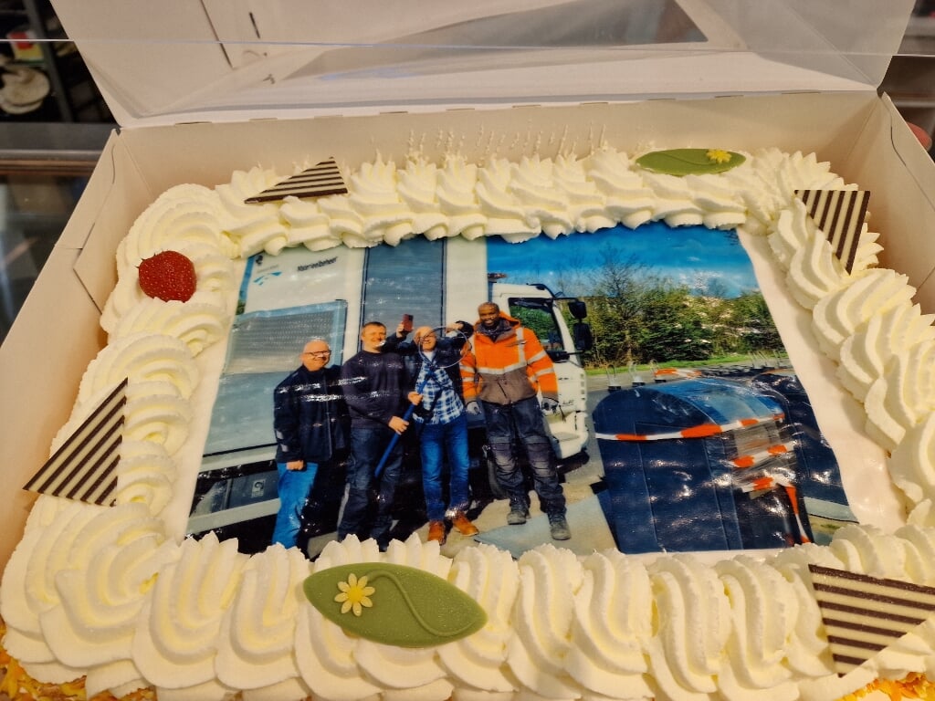 De Van Saagsvelts trakteerden stadsreiniging met een taart waarop een gelukkige Jan van Saagsvelt staat afgebeeld. Met telefoon. (Foto: aangeleverd)