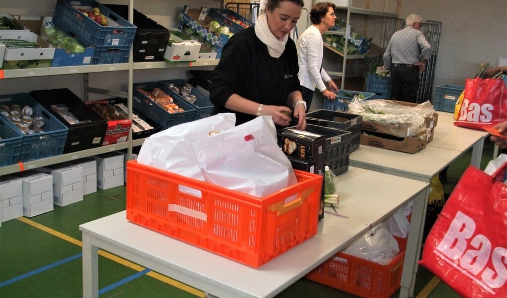 Bij de voedselbank in Zwijndrecht worden de voedselpakketten van tevoren ingepakt en klaargezet voor de afnemers. Daarbij wordt de afstand van 1,5 meter strikt in acht genomen.