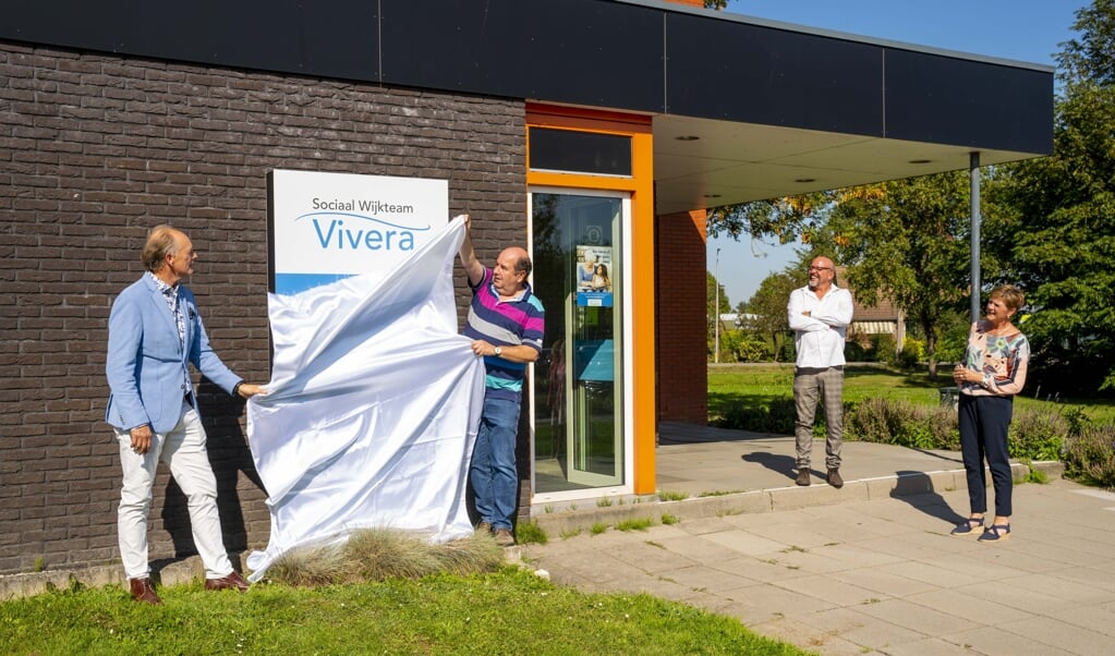 Wethouder Ronald de Meij onthult samen met medewerkers van het Vivera Sociaal Wijkteam het nieuwe logo voor de deur van hun pand.