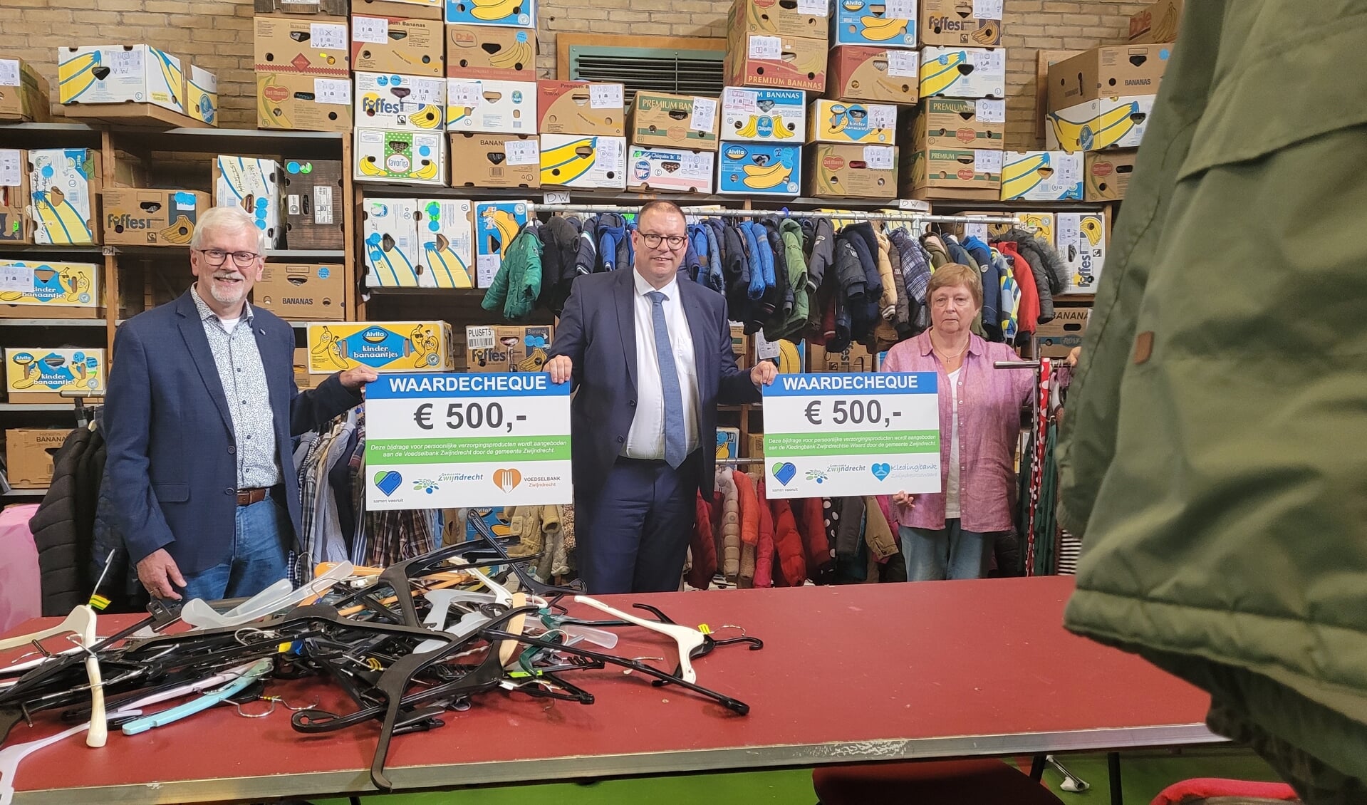 Wethouder Tycho Jansen (midden) overhandigde de cheques vanmiddag aan Wim Sandee van de Voedselbank (links) en Laura Bosman van de Kledingbank (rechts)