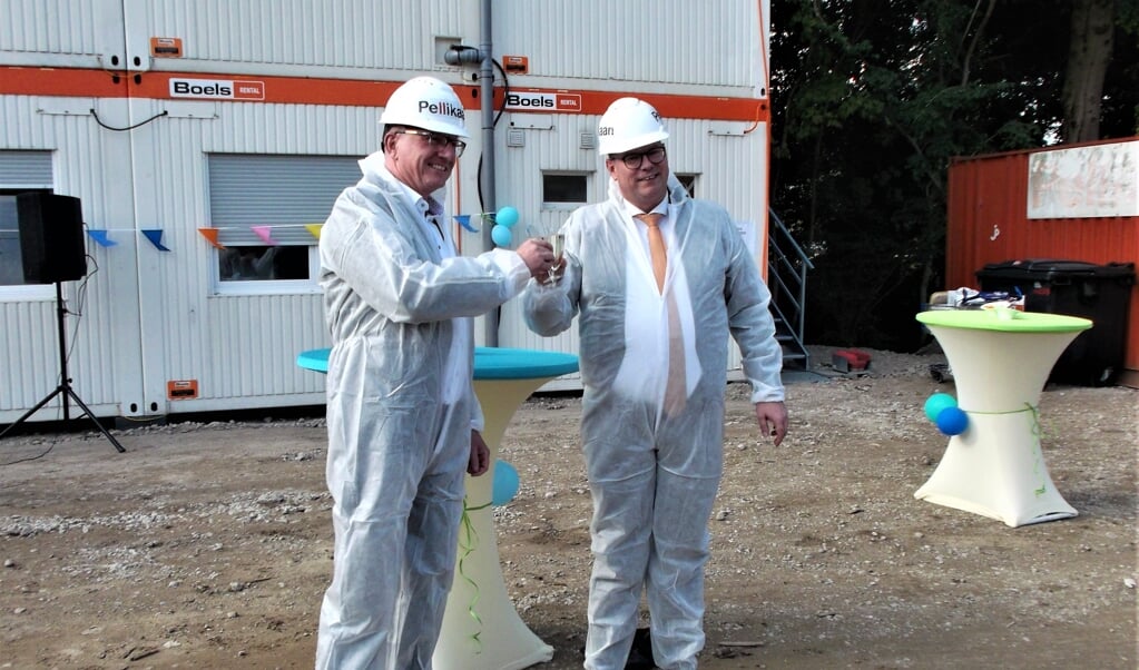 Wethouder Tycho Jansen (rechts) en Jack Hazen, directeur van Pellikaan Bouwbedrijf heffen het glas op een voorspoedige bouw van het nieuwe zwembad.
