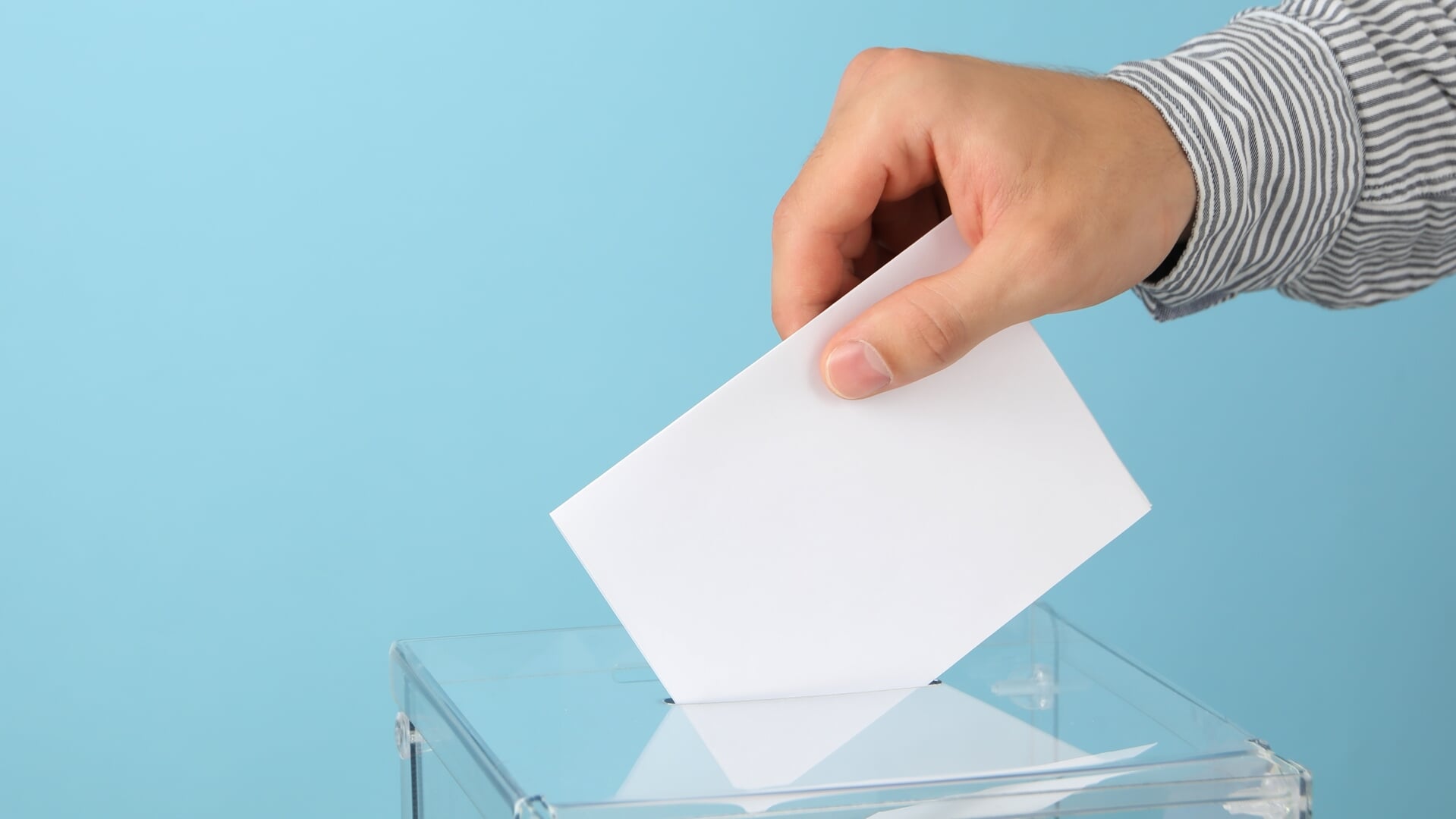 Man putting ballot into voting box on blue background