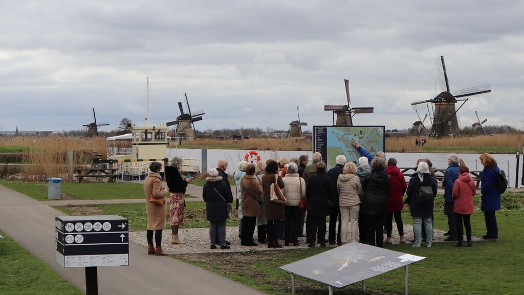 Eén van drie groepen vrijwilligers met de gids, met op de achtergrond de molens.