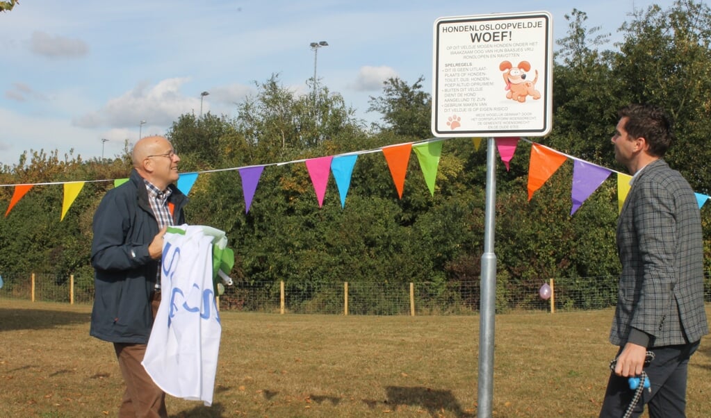 Kees Gravemaker van het Dorpsplatform Woensdrecht en wethouder Jeffrey van Agtmaal bij een eerder project in het dorp, de opening van hondenlosloopveldje Woef! aan de Fortuinstraat. 