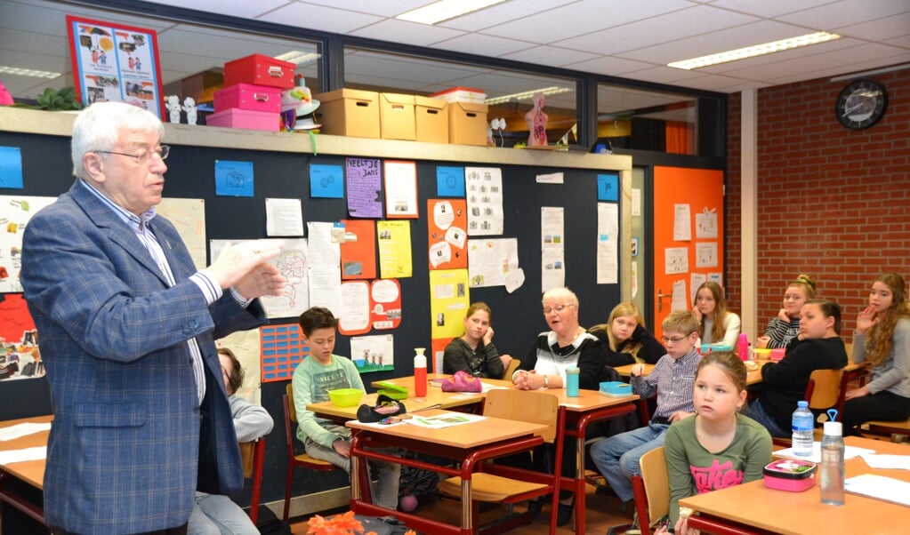 Leerlingen in groep 7/8 van de Springplank luisteren naar het verhaal van Maarten van Eekelen over de watersnood. 