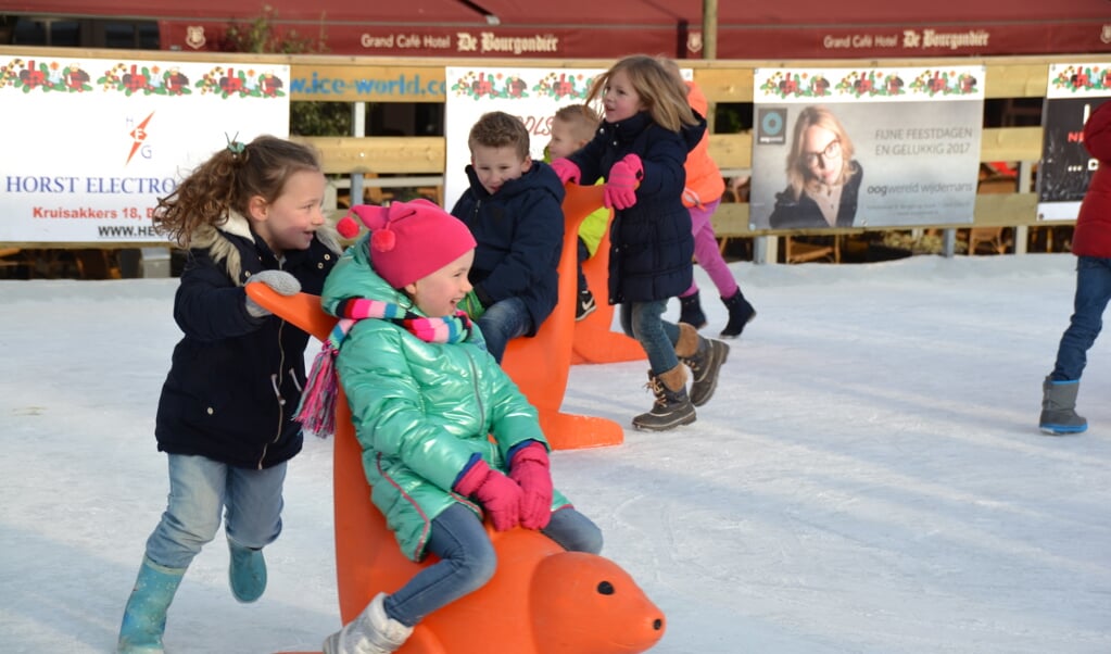 De kinderen vermaken zich grandioos met én op de schaatshulpen.