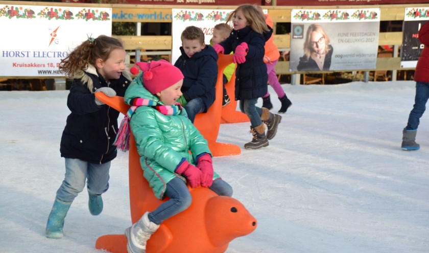 De kinderen vermaken zich grandioos met én op de schaatshulpen.