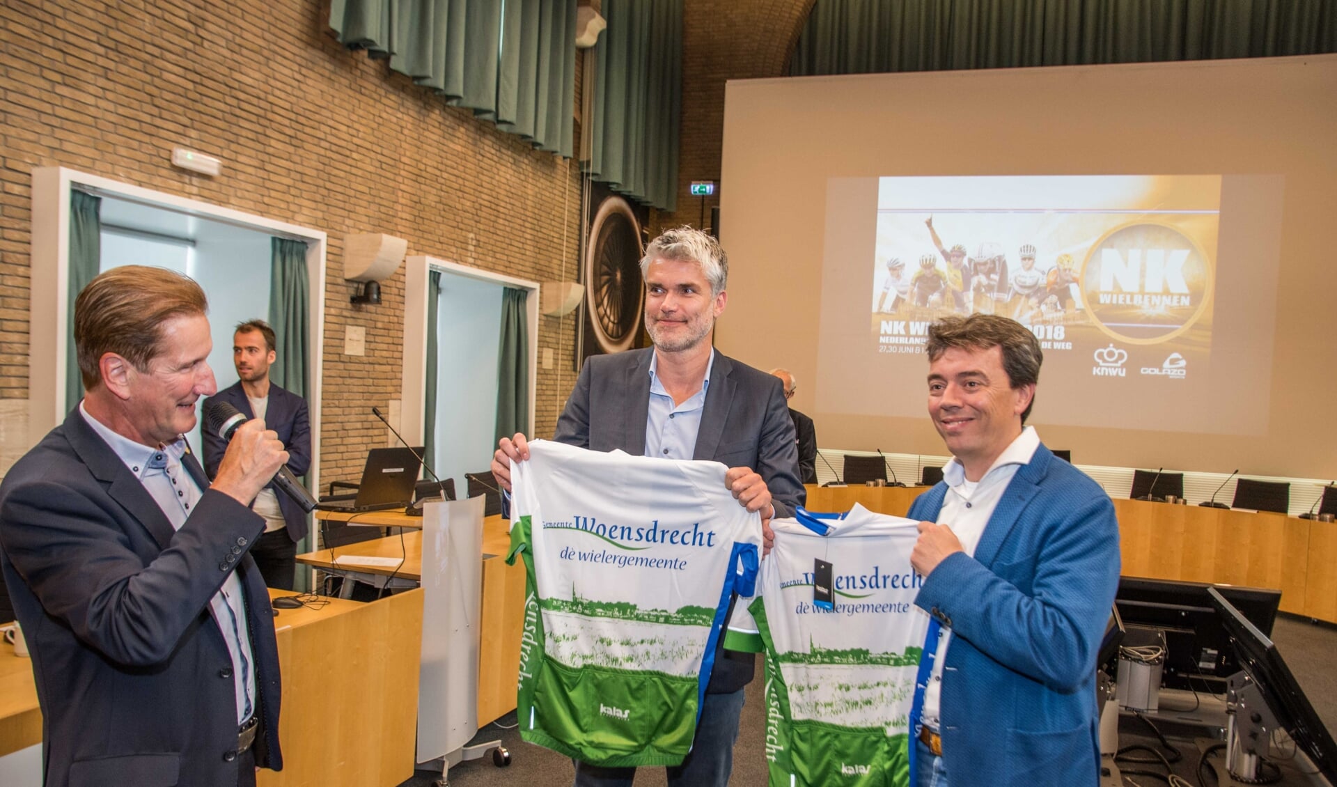 KNWU-directeur Vincent Luijendijk en Dimitri Bonthuis van Golazo ontvingen van wethouder de Waal een wielershirt.