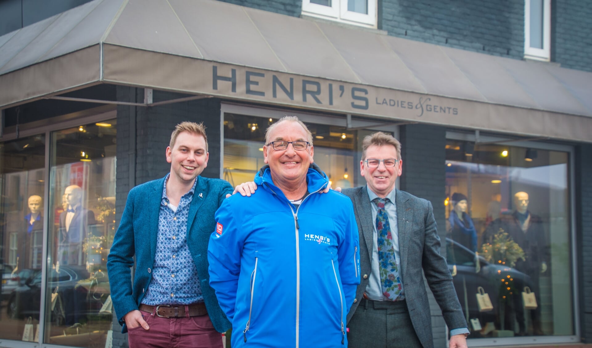 Bram en Harry Beening van Henri's Ladies & Gents poseren met Wielercomité-vrijwilliger Cees van Wijk, die zijn NK-jas draagt.