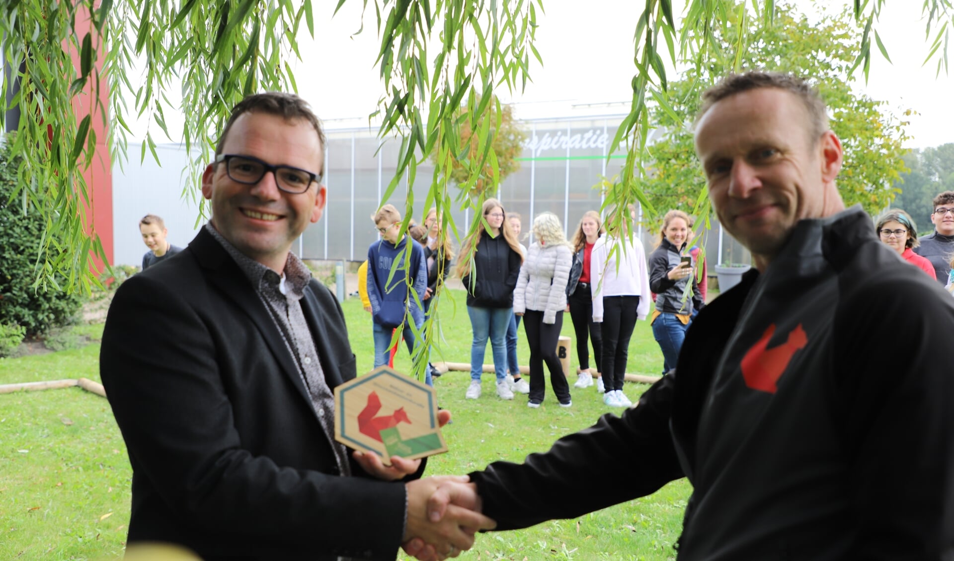 Schoolmanager Michel van Loon van Curio - Steenspil neemt de plaquette in ontvangst  uit handen van Robert Deliën van het Natuurpodium.
