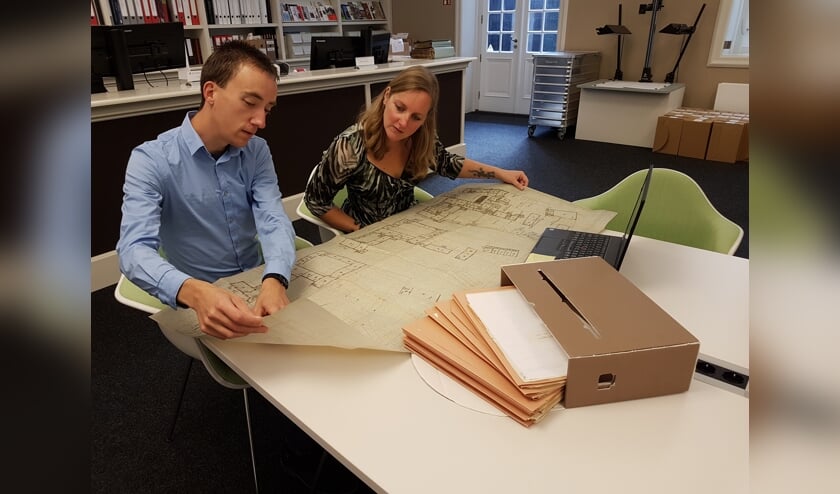 <p>Archieffoto: Onderzoeker Bart van Eekelen toont medewerker Dienstverlening Saskia van Bavel een plattegrond van het Markiezenhof die het West-Brabants Archief voor hem heeft gedigitaliseerd.</p>