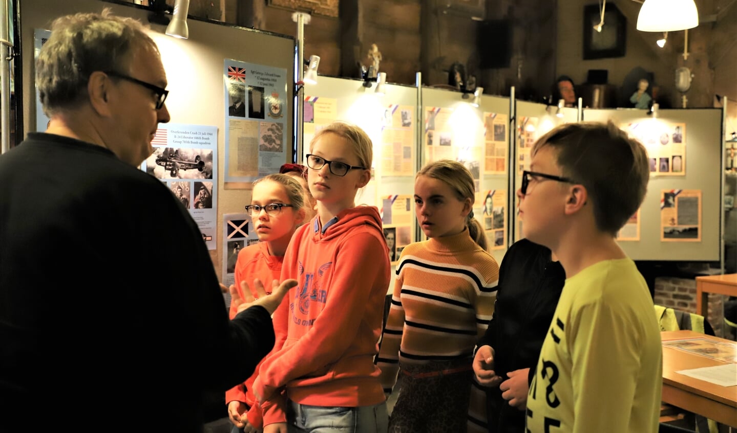 Schoolkinderen bekijken aandachtig de tentoonstelling over de Tweede Wereldoorlog die is opgezet bij heemkundekring Halchterth in Hof van Ram. 