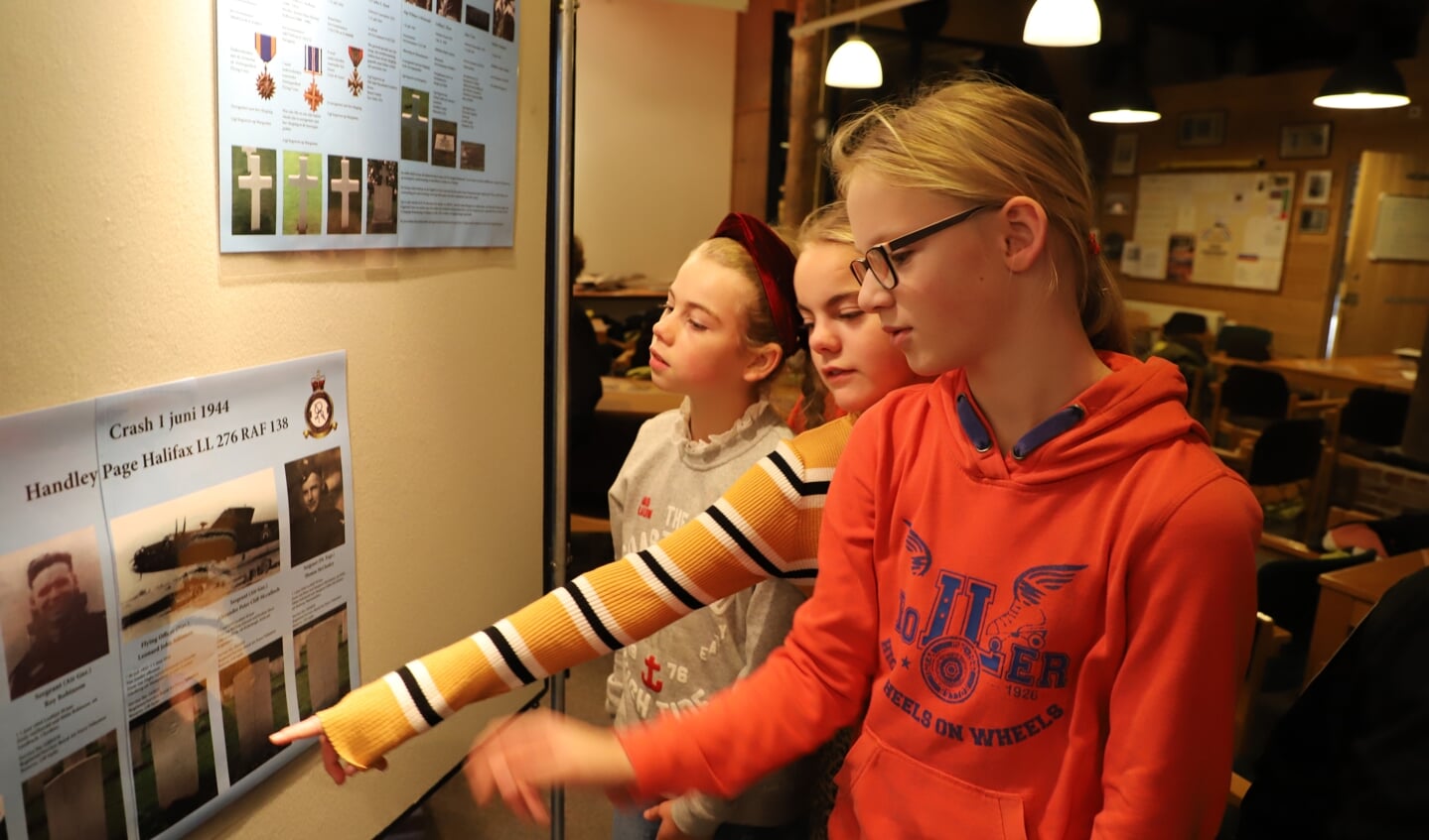 Schoolkinderen bekijken aandachtig de tentoonstelling over de Tweede Wereldoorlog die is opgezet bij heemkundekring Halchterth in de Hof van Ram. 