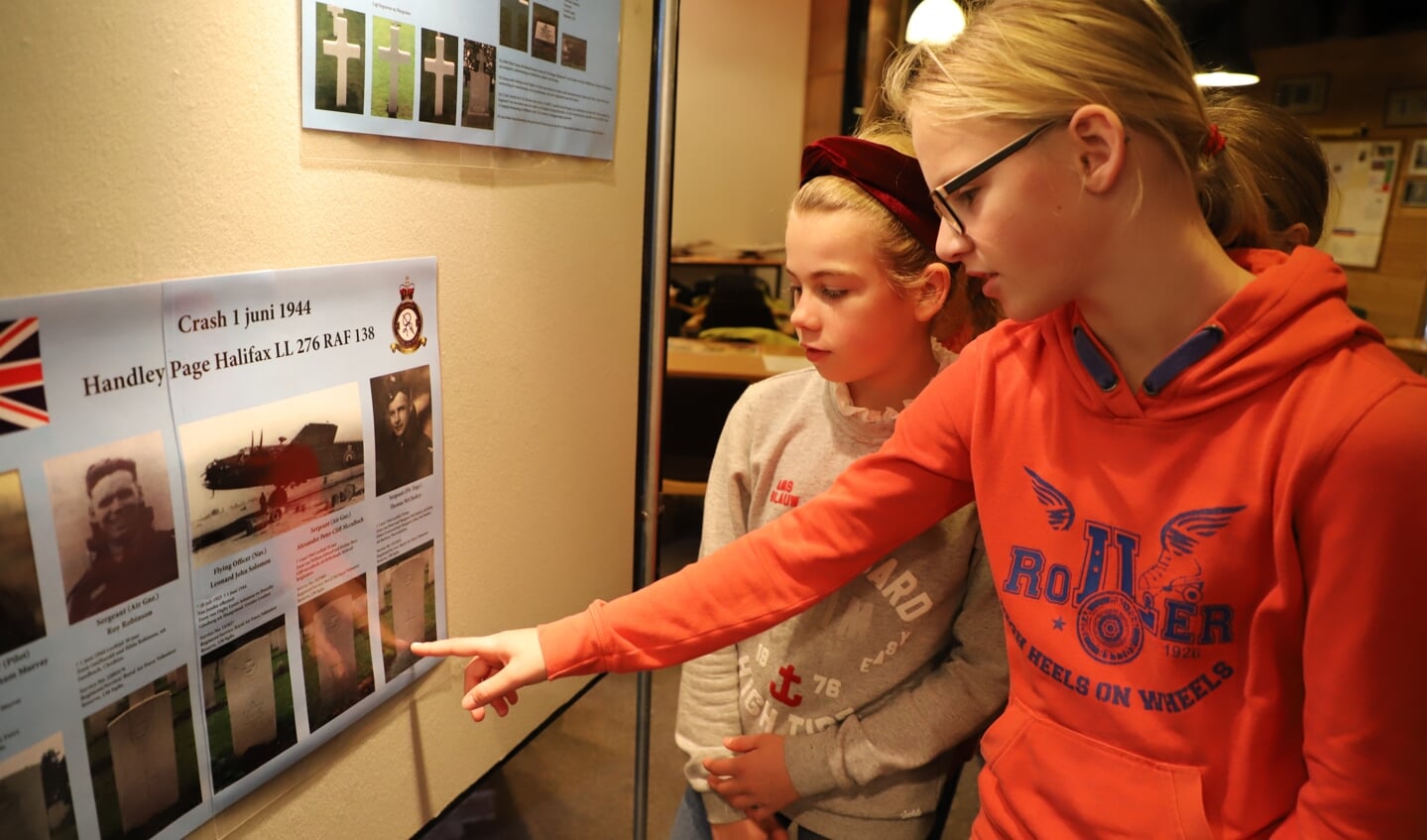 Schoolkinderen bekijken aandachtig de tentoonstelling over de Tweede Wereldoorlog die is opgezet bij heemkundekring Halchterth in de Hof van Ram. 