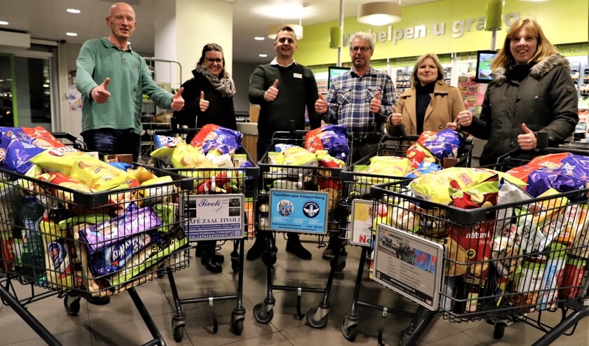 Leden van het winnende quizteam Kannebuis/Olympus 1 krijgen hun hoofdprijs uitgereikt door Rik Linssen van PLUS Halsteren.