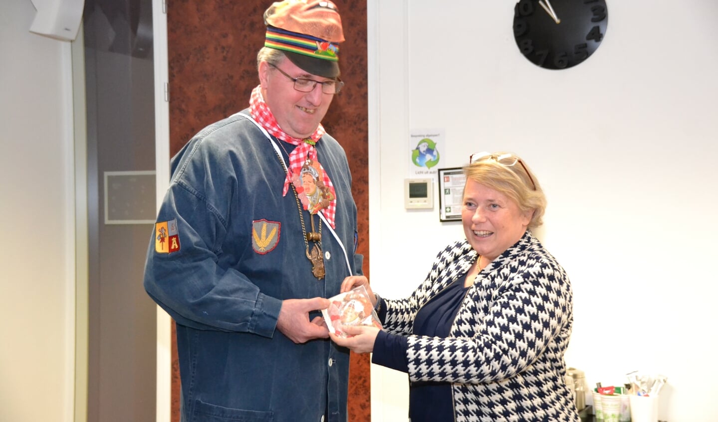Voorzitter Stichting Alterse Carnaval John van Tilburg overhandigt het insigne aan wethouder Annette Stinenbosch.