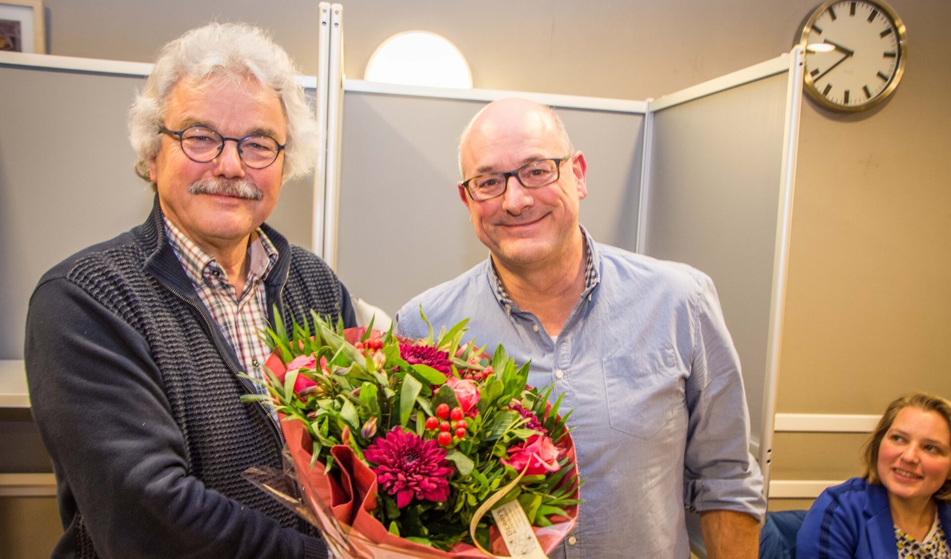 Vertrekkend voorzitter Jac Smeijers (links) krijgt bloemen van zijn opvolger Gerard van den Bergh.