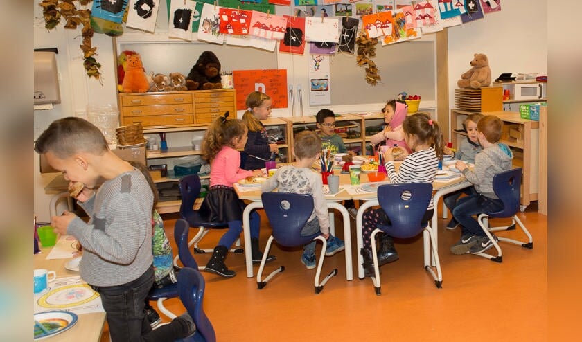 Kinderen genieten op de basisschool van een gezond Koningsontbijt.