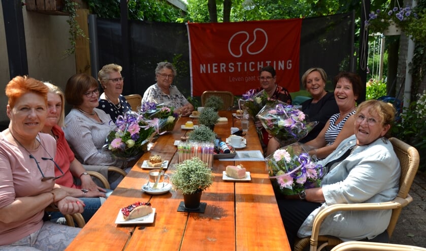 Jubilarissen met bloemen tussen anderen die zich al jarenlang inzetten voor de Nierstichting.