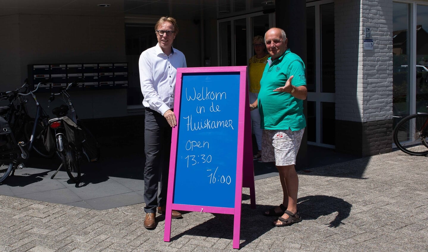 Wethouder Lars van der Beek en dhr. Adriaansen openden de nieuwe huiskamer door het welkom-bord buiten te plaatsen.