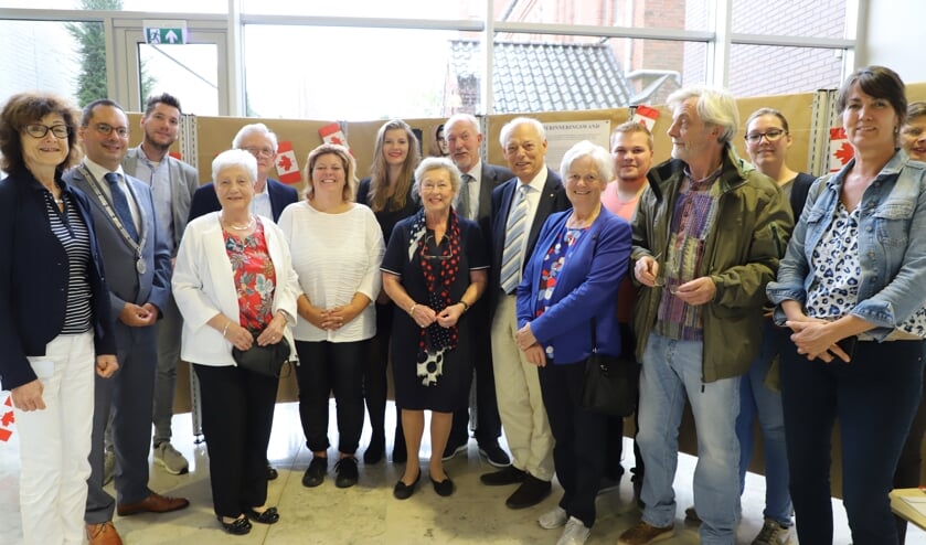Familie van de 75 jaar geleden gefusilleerde Sjef Adriaansen en gemeentebestuurders bij de herinneringswand.