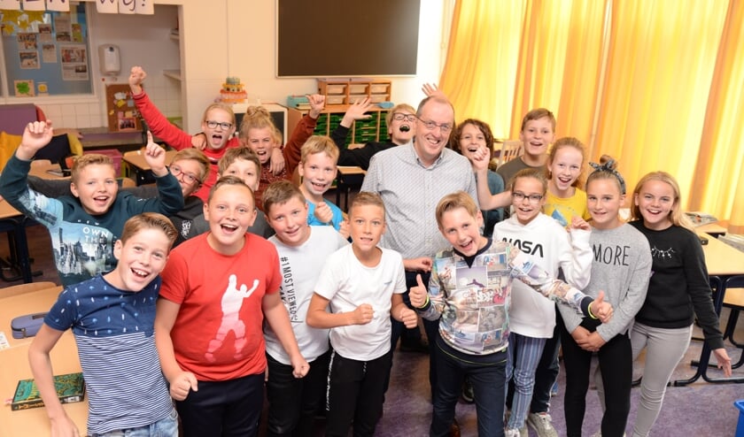 Schooldirecteur Jack Nuijten tussen leerlingen van de Sint Maartenschool.